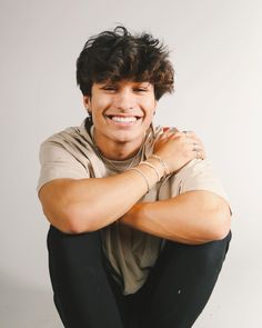 a smiling young man with his arms crossed