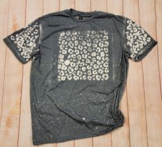 a black t - shirt with leopard print on the front and white spots on the back