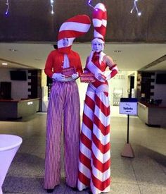 two people dressed in red and white striped outfits standing next to each other with their hands on their hips