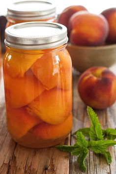 canning peaches for beginners in a mason jar on a wooden table with mint leaves