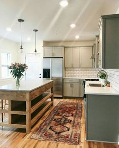 a kitchen with an island, sink and stove top oven next to a refrigerator freezer