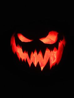 a carved pumpkin with glowing eyes and teeth