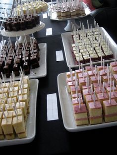 desserts are displayed on white trays with toothpicks in the shape of squares