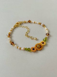 Bracelet Length: 6-8 inches 

Each Bracelet has a 2 inch 14k gold filled extender

This bracelet features different shades of hand woven yellow sunflowers and fall colors of cream, brown, green, and gold. 

This dainty piece is made up of high quality seed beads including 24kt gold plated beads, crystals, and tigers eye.

Strung on: Non-Stretchy Beading Thread
#sunflowers #aestheticoutfit #falloutfitideas #autumnmood #fallfashiontrends #falljewelry #beaded #whimsical #goldjewelryideas #cottagecore Sunflower Beaded Bracelet, Pretty Beaded Jewelry, Aesthetic Sunflower, Daisy Chain Bracelet, Bracelet Aesthetic, Sunflower Bracelet, Braided Bracelet Diy, Pretty Jewelry Necklaces, Bracelets Handmade Diy