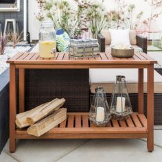 a wooden table with candles and other items on it in front of a patio area