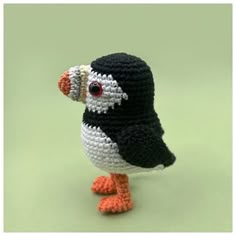 a crocheted bird is standing on one leg