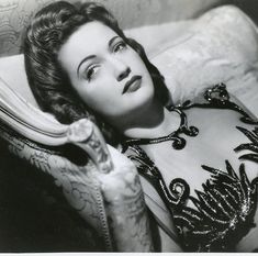 an old black and white photo of a woman laying down with her hand on her hip