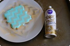 a white plate topped with cookies next to a can of color mist spray on top of a table