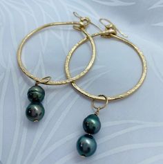 ELUA DOUBLE HOOP EARRINGS. Live a little with these fun and sparkly earrings made with double Tahitian black cultured pearls, dangling from a pair of gold textured hoops. Each earring has two AA+ 9mm pretty round pearls with greenish blue tones. Each pearl is one of a kind and no two pearls are exactly the same. Color of pearl may vary from photos. Hoops are hammered textured 35mm 18K gold-filled with French hooks. Each piece from my collection is handmade, designed and crafted by me. The Tahiti Tahitian Pearl Dangle Earrings Gift, Gold Tahitian Pearl Earrings Gift, Gold Tahitian Pearl Earrings For Anniversary, Gold Tahitian Pearl Drop Earrings, Double Hoop Earrings, Sparkly Earrings, Greenish Blue, Pearl Hoop Earrings, Wire Crafts