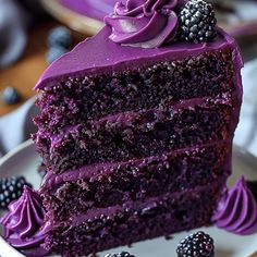 a slice of cake with purple frosting and blackberries