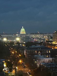 the city skyline is lit up at night, with buildings in the foreground and lights on