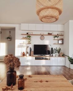 a living room filled with furniture and a flat screen tv on top of a wooden table