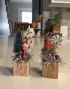 two small christmas decorations sitting on top of a counter