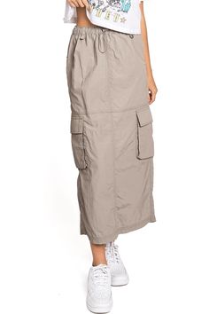 Chic, parachute skirt with an elastic waistband, a drawstring cinch tie and cargo pockets down the sides. Pair it with a graphic tee and sneakers for an effortless streetwear look. CARE | Machine Wash Cold CONTENTS | 100% Nylon MEASUREMENTS | 33"/85 cm Top to Bottom (Size Small) MODEL | 5'8 - wearing a size Small IMPORTED Summer Utility Cargo Skirt With Drawstring, Casual Cargo Skirt With Drawstring For Summer, Casual Drawstring Cargo Skirt For Summer, Casual Summer Cargo Skirt With Drawstring, Spring Utility Cargo Skirt With Drawstring, Summer Utility Parachute Pants With Drawstring, Utility Cargo Skirt With Elastic Waistband, Spring Bottoms With Drawstring For Outdoor Activities, Casual Parachute Pants With Functional Drawstring For Spring