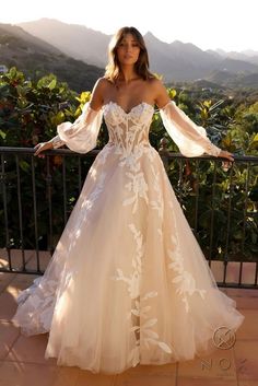 a woman in a wedding dress standing on a balcony with her arms spread out and looking at the camera