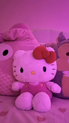 a hello kitty stuffed animal sitting on top of a bed next to a teddy bear