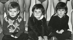 black and white photograph of children sitting on the floor with their backs turned to one another