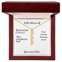 a gold necklace with the names of two people on it in a wooden display case