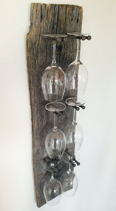 several wine glasses are hanging from a wooden wall rack with glass holders on the side