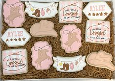 decorated cookies in a gift box with pink and brown designs on them, including cowboy hats