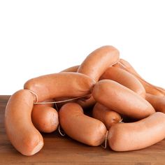 a pile of hot dogs sitting on top of a wooden table