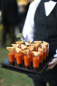 a tray with orange juice and crackers on it is being held by a waiter