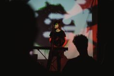 a woman standing on top of a stage next to a microphone