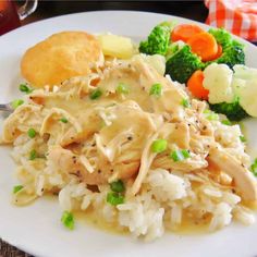 a white plate topped with chicken, rice and veggies