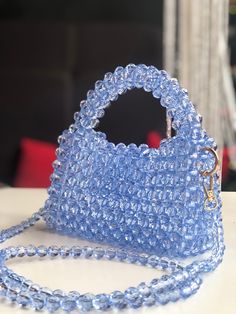 A soft blue beaded bag is an elegant accessory that attracts the eye with its delicate shade of blue and the shine of the beads. It is made from high quality materials, creating a sophisticated and sophisticated look. This bag is perfect for special occasions when you want to add a touch of luxury and femininity to your look. Elegant Light Blue Top Handle Bag, Elegant Light Blue Rectangular Shoulder Bag, Blue Handmade Evening Bag For Everyday Use, Elegant Handmade Blue Shoulder Bag, Light Blue Rectangular Evening Bag, Blue Tote Shoulder Bag For Party, Elegant Blue Bag With Pearl Handle, Elegant Light Blue Bags For Party, Elegant Light Blue Party Bags