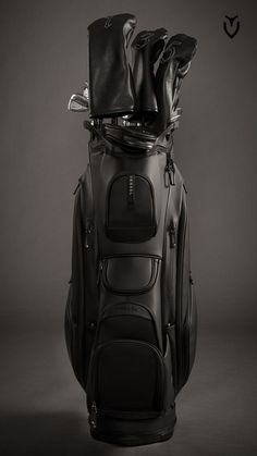 a black and white photo of a golf bag with four pairs of shoes on top