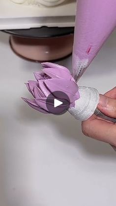 a person is cutting paper with a sharpie knife on top of a cake plate