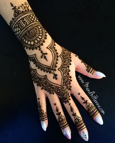 a woman's hand with henna tattoos on it