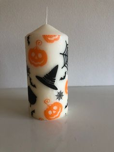 a white candle with halloween decorations on it