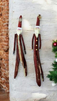 christmas decorations made out of wooden sticks hanging on a wall in front of a tree