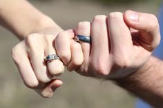 two people holding hands with their wedding rings on top of each other's fingers