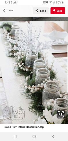 the table is decorated with mason jars and greenery