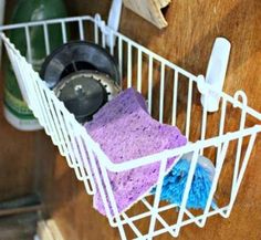 a white wire basket filled with cleaning supplies