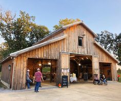 people are standing in front of a barn