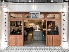 the entrance to a restaurant with people sitting at tables in front of it and an open door