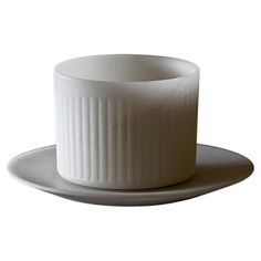 a white cup and saucer on a plate