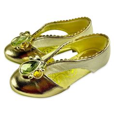 a pair of gold shoes with green jewels on them