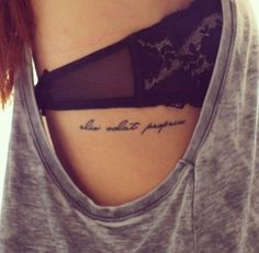 a woman with a tattoo on her chest saying, she is not supposed to die