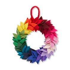 a multicolored felt wreath hanging on a white wall