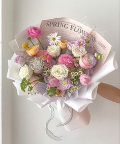 a bouquet of flowers sitting on top of a white paper wrapped in some kind of wrapper