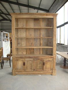 an old wooden bookcase is being displayed in a room with tables and other furniture