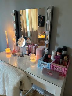 a white desk topped with a vanity mirror and lots of makeup on top of it