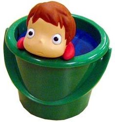 there is a plastic toy boy in a green cup