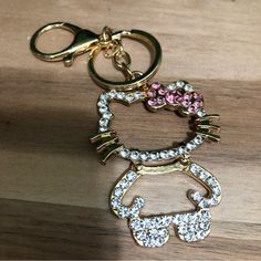 a hello kitty keychain with pink and white crystals