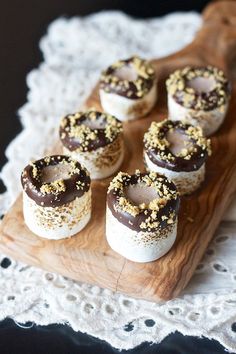 chocolate covered donuts with sprinkles on a wooden tray