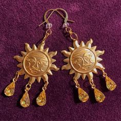 Bring a solar smile to the face of all that look upon your beauty with these dazzling sun drop earrings. These little works of art feature raw stamped brass charms of the smiling sun, and from the smiling sun hangs three vintage pear cut jonquil yellow glass charms. These glass charms have undertones of red, orange, yellow, and green to keep the spectrum of the sun sparkling around you! The earring hook has a clear glass crystal charm and is plated in 22k gold which is perfect for sensitive ears Gold Symbolic Earrings With Sun And Moon Design, Symbolic Gold Earrings With Sun And Moon Design, Spiritual Sun And Moon Design Earrings For Festival, Gold Sun And Moon Festival Jewelry, Festival Sun And Moon Dangle Jewelry, Gold Celestial Earrings With Sun Design, Gold Sunburst Earrings With Sun Design, Gold Sun And Moon Design Jewelry For Festivals, Gold Dangle Earrings With Sun And Moon Design